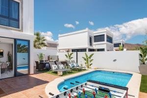 a villa with a swimming pool and a house at Villa Acacia in Yaiza