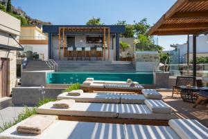 a backyard with a pool with chaise lounges and a house at Casa D'Irene Deluxe Hotel in Falasarna