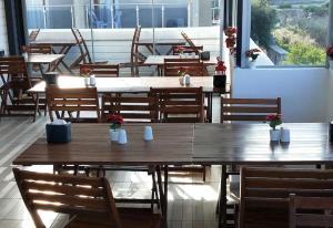 a group of tables and chairs in a restaurant at Saatlı Hotel in Çeşme