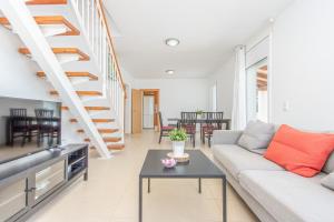 een woonkamer met een bank en een trap bij Apart-rent Casa con piscina Alberes 0005 in Empuriabrava