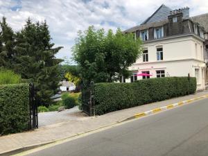 a white house with a fence on the side of a street at Villa les Tamaris in Spa