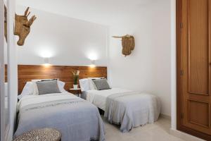 two beds in a room with white walls at Villa Acacia in Yaiza