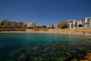 una playa con un montón de gente en el agua en Cal Morrudet, en L'Ametlla de Mar