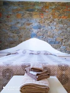 een slaapkamer met een bed met een stenen muur bij La Rosa dei Venti in Cantagrillo