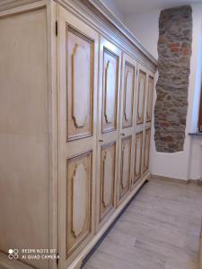 a row of wooden doors in a room with a stone wall at La Rosa dei Venti in Cantagrillo