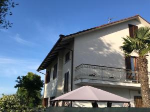 un bâtiment blanc avec un parasol et un palmier dans l'établissement Regina di Cuori Rooms, à SantʼElpidio a Mare