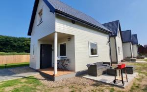 a tiny house with a porch and a patio at Baltic Beach House in Rewal