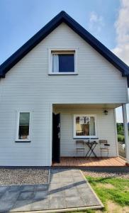 a white house with a picnic table in front of it at Baltic Beach House in Rewal