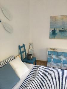 a bedroom with a bed and a chair and a painting at Dom pod Białym Pagajem in Pisz