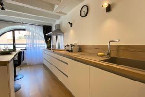 a kitchen with a sink and a clock on the wall at Le Royal 4 - Apartment for 4 people in the city center in Annecy
