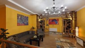 a living room with a couch and a chandelier at Hotel Soft in Batumi