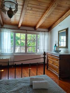 a bedroom with a bed and a dresser and windows at Liknon Guesthouse Villa in Galaxidi