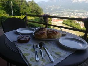 a table with plates of croissants and utensils on at DOLCE DORMIRE in Rovereto