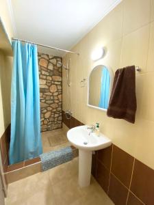 y baño con lavabo y ducha. en Livia’s Appartments en Pafos