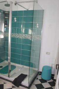 a bathroom with a shower with a blue tile wall at STUDIO TURQUOISE Victoria in Bucharest +4 photos