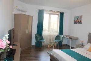 a hotel room with a bed and a desk and chairs at STUDIO TURQUOISE Victoria in Bucharest