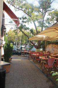 una cafetería al aire libre con mesas, sillas y sombrillas en STUDIO TURQUOISE Victoria, en Bucarest