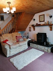 a living room with a couch and a fireplace at Carnowen Cottage in Ringsend