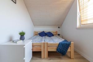 MorzeZatoka - apartamenty Władysławowo في فواديسوافوفو: غرفة نوم بها سرير مع وسائد زرقاء