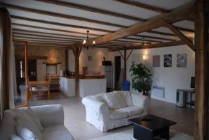 a living room with two white couches and a kitchen at La Grange in Vanzay