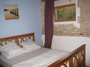 1 dormitorio con cama y ventana en La Grange, en Vanzay