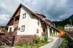 een huis met een houten hek ervoor bij Pension Csomád in Băile Tuşnad