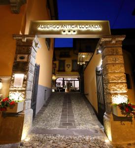 an alley in a building with a sign that reads albergo antico la at Albergo Antica Locanda in Clusone