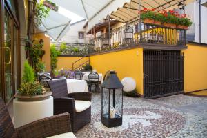 un patio con tavolo e sedie e un balcone. di Albergo Antica Locanda a Clusone