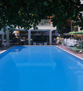 een groot blauw zwembad voor een gebouw bij Hotel Susy in Rimini