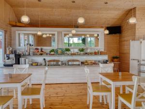 a kitchen with white tables and chairs and a counter at Willa Perła Krynicy in Krynica Morska