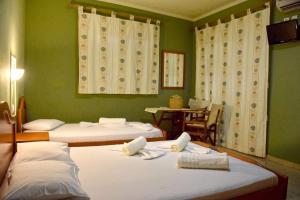 two beds in a room with green walls at Villa Maria in Sarti