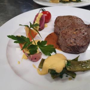 ein weißer Teller mit Steak und Gemüse drauf. in der Unterkunft Finkennest in Annweiler am Trifels