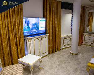 a living room with a flat screen tv and curtains at Hotel Mamounia Boutique in Prishtinë