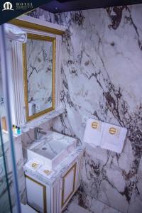 a marble bathroom with a sink and a mirror at Hotel Mamounia Boutique in Prishtinë