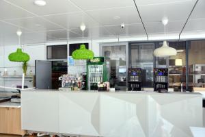 a counter in a restaurant with green pendant lights at Hotel Fortuna in Eforie Nord