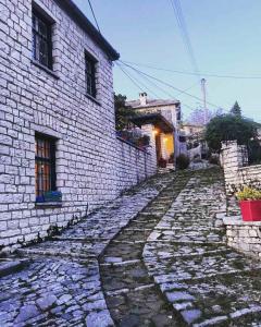 uma velha estrada de pedra ao lado de um edifício de tijolos em Guesthouse Selini em Vitsa