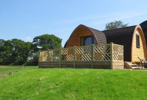 a house with a wooden fence in front of it at Archers Meadow Shropshire in Ellesmere