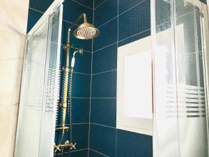 a shower in a bathroom with a blue tiled wall at Casita Marinera in Peniscola