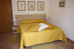 una camera con un letto giallo con due cuscini sopra di Le Tre Sorelle a Testaccio a Roma