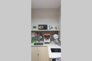 una pequeña cocina con fregadero y microondas en 3 Elements-FIFA-MRT2 Station-WiFi-Self Check-iN, en Seri Kembangan