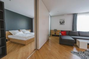 オラデアにあるAPARTHOTEL Panoramis Residenceのベッドルーム(ベッド1台、ソファ、鏡付)