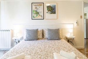 a bedroom with a large bed with blue and white pillows at “Ivory house”with sea view in Manarola