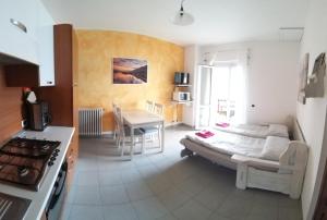 a room with a bed and a kitchen with a table at Residence Casa Rosa in Gera Lario