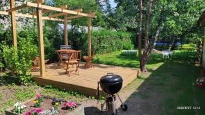 une terrasse en bois avec une table et un grill dans l'établissement Oakcorner Place Apartment, à Haapsalu