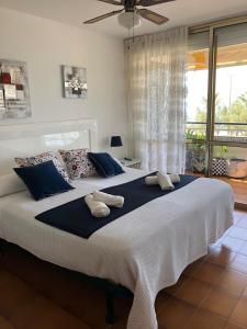 een slaapkamer met een groot bed met kussens en een raam bij Face à La Mer in Calafell