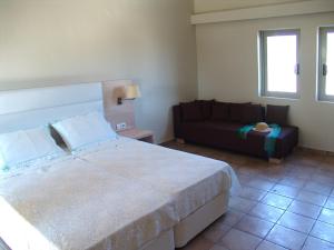 a bedroom with a large bed and a couch at Enalia Gi in Límni