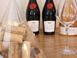 two bottles of wine and a glass on a table at Le Relais Des Dix Crus - Logis Hôtel in Corcelles-en-Beaujolais