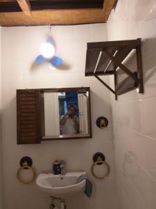 un uomo che scatta una foto di un bagno con lavandino di La tana del porto a Napoli