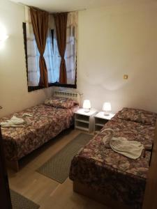 a hotel room with two beds and a window at Linden Tree Apartment in Fojnica
