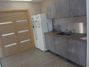 cocina con nevera blanca y fregadero en maison de vacances en Grandcamp-Maisy